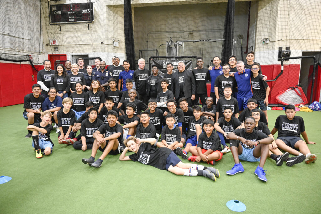 Group of athletes and coaches pose for photo.